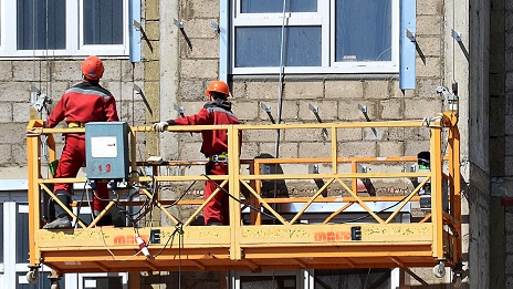 Workers On A Suspended Scaffold Mount Fasteners For A Rainscreen.